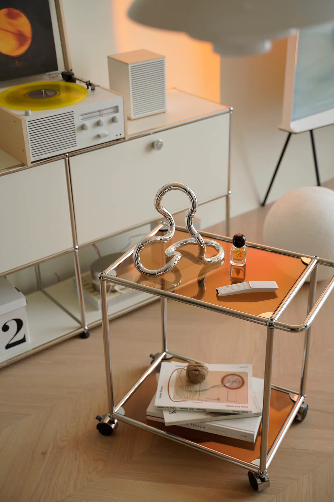 Inspired recreation USM modular small glass handcart with decorative items in a room setting.