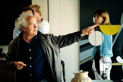 USM designer fritz-haller pointing at a design with a woman and another person in the background
