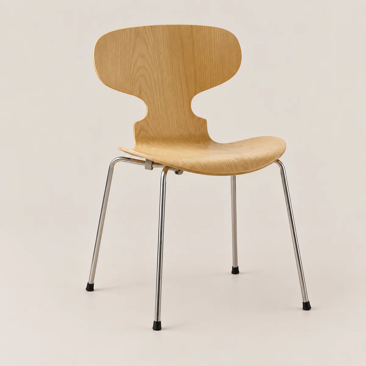 A modern wooden dining chair with a light natural oak seat and backrest, supported by slim chrome metal legs with black rubber feet, set against a plain beige background.