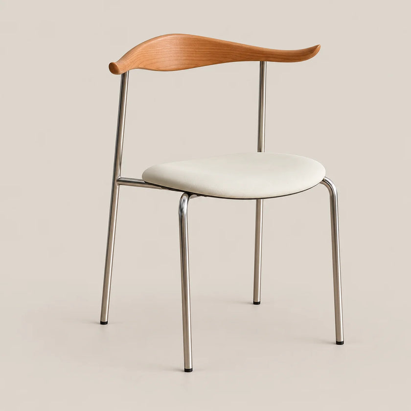 A modern dining chair with a curved light oak wood backrest, a cream upholstered seat cushion, and slim polished steel legs, shown against a solid beige background.
