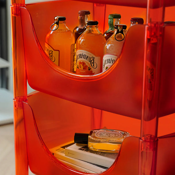 Close-up of a transparent orange chair with bottles and books inside
