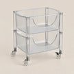 A two-tier clear plastic rolling storage cart with a semi-circular basket design on each level, supported by clear acrylic side rails and four caster wheels, shown against a solid light beige background.