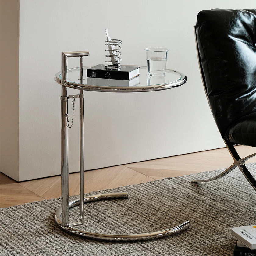 Modern side table with glass top and metal base in a minimalistic room.