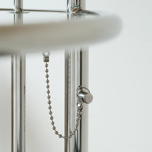 Close-up of a shower door handle with chain on a glass shower enclosure.