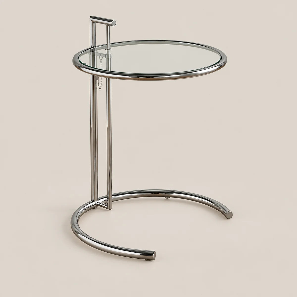 A modern round side table with a clear glass top and a polished chrome metal base, shown against a solid beige background.