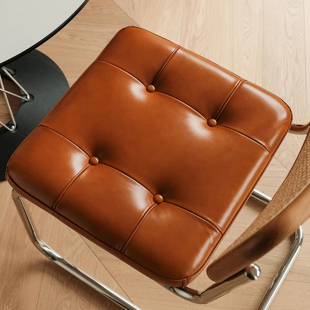 Brown leather chair with metal legs on a wooden floor