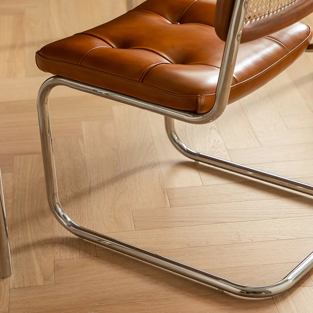 Brown leather chair with metal frame on a wooden floor