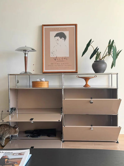 Modern storage unit with glass panels and beige drawers in a room with a cat and decor items.