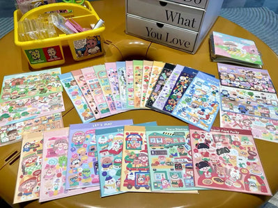 Collection of colorful stickers on a table with a yellow storage box labeled 'What You Love'.