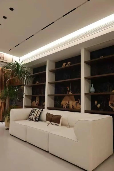 Modern living room with a white sofa and decorative shelves.