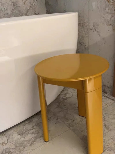 Yellow side table against a white sofa and gray wall.