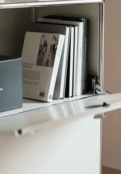 Books on a shelf inside a white cabinet with a neutral background