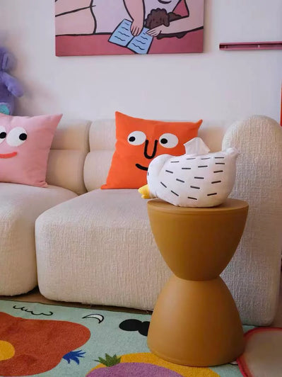 Children's room with colorful pillows and a small table.