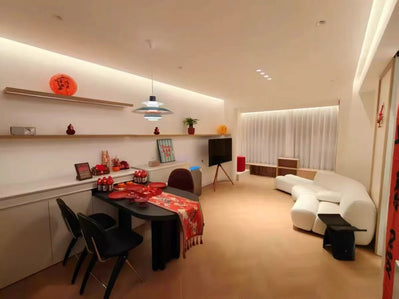 Modern living room with white sofa, dining table, and decorative items.