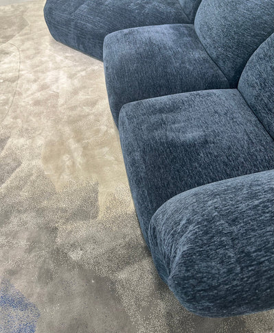 Blue textured sofa on a beige carpet