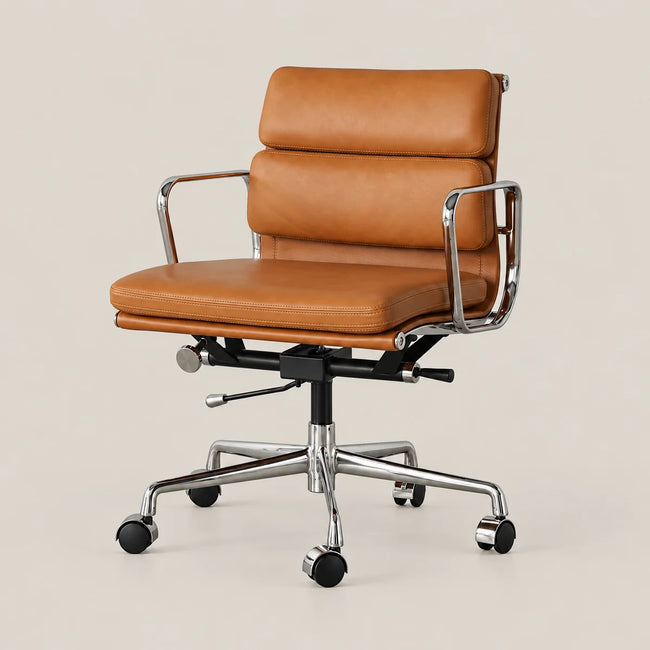 A mid-century modern office chair with tan leather upholstery and a polished chrome steel frame, base, and five-star rolling wheel structure, set against a solid light beige background.