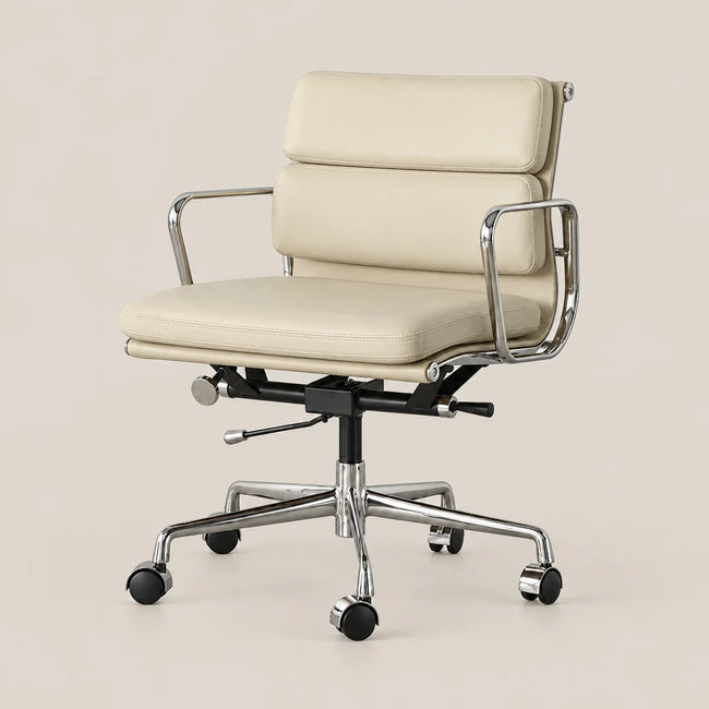 A modern office chair with cream-colored leather upholstery and a polished chrome metal frame, base, and casters, shown against a solid light beige background.
