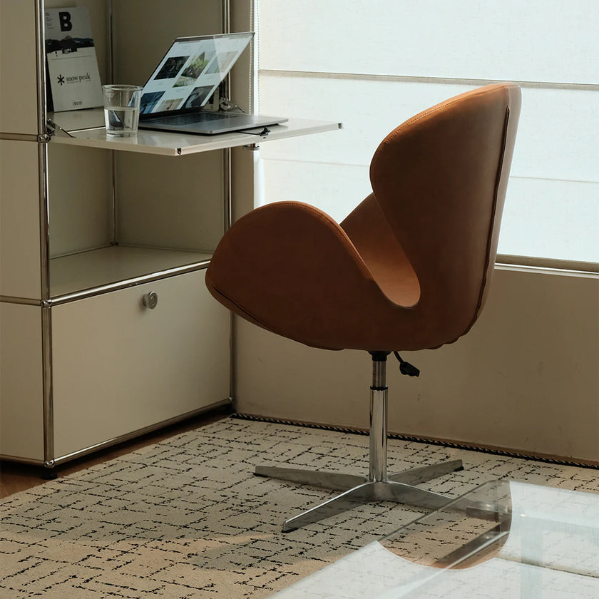 Brown chair in a room with a desk and window