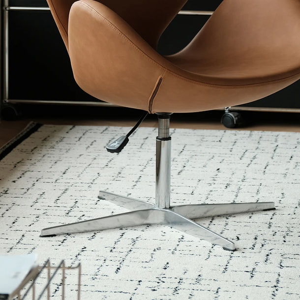 Brown office chair with a metal base on a textured floor