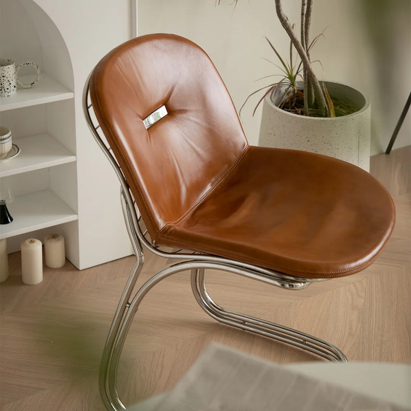 Brown leather chair with metal frame in a room setting