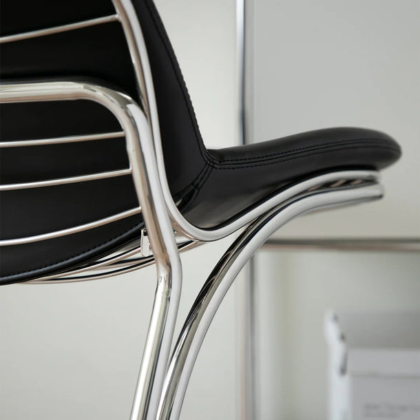 Modern black chair with chrome frame on a light gray background