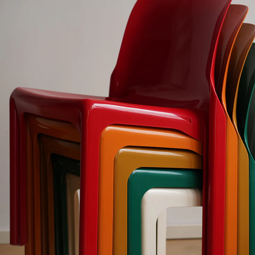 Stacked colorful chairs in various colors on a neutral background
