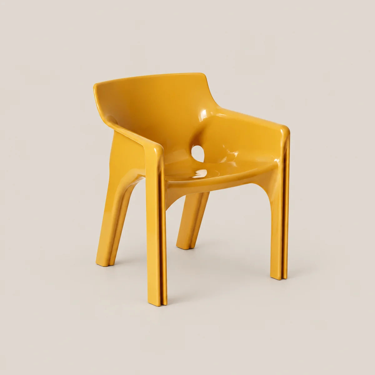 A modern, molded plastic armchair in a vibrant mustard yellow color, shown from a three-quarter angle against a solid, warm off-white background.