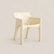 A modern molded plastic armchair in a glossy cream color, set against a solid, warm off-white background.