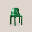 A glossy green molded plastic chair shown from a three-quarter angle against a solid, warm beige background.
