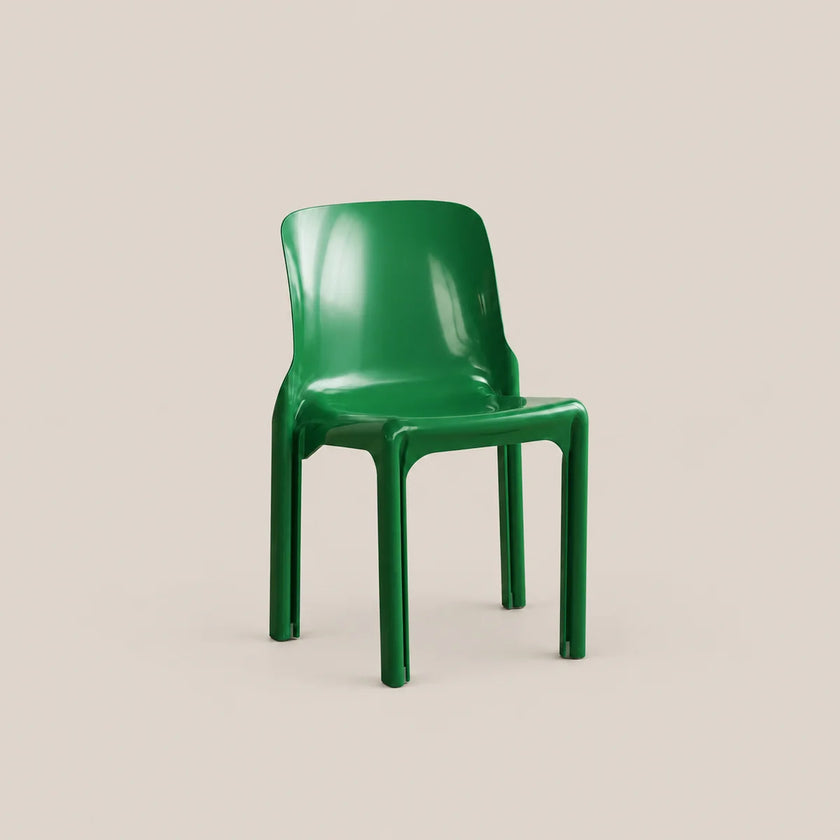 A glossy green molded plastic chair shown from a three-quarter angle against a solid, warm beige background.