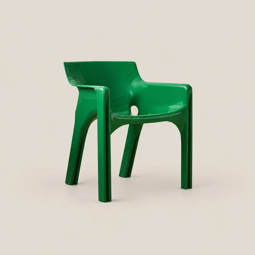 A glossy bright green molded plastic armchair shown on a plain warm beige studio background.