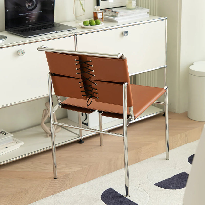 Brown chair with metal frame in a room with a desk and computer.