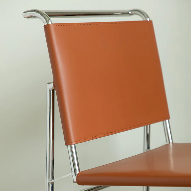 Brown chair with metal frame on a plain background