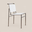 A modern dining chair with a white upholstered seat and backrest, supported by a slim brushed metal frame, shown against a solid beige background.