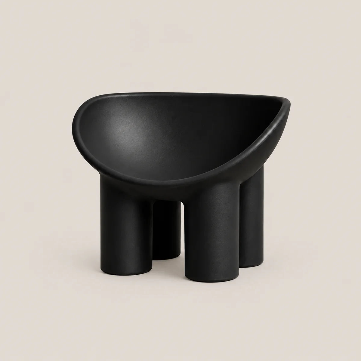 A minimalist black molded stool with a rounded, bowl-like seat and four cylindrical legs, shown against a solid light beige background.
