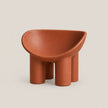 A terracotta-colored molded plastic children's stool with a rounded, bowl-like seat and four cylindrical legs, shown against a solid light beige background.
