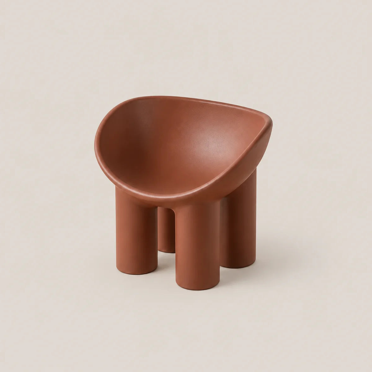 A small terracotta-colored molded stool with a rounded, bowl-like seat and four cylindrical legs, shown on a plain warm beige background.