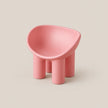 A small modern pink stool with a rounded, organic-shaped seat and four cylindrical legs, shown on a plain warm beige background.