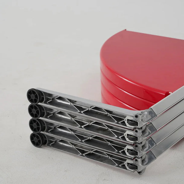 Metallic folding stand with red circular objects on a light gray background