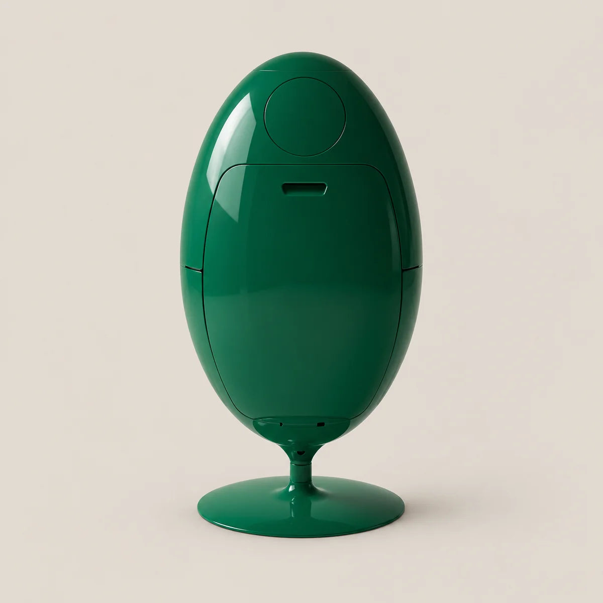 A glossy dark green egg-shaped electronic device on a matching circular pedestal base, photographed against a solid light beige background.