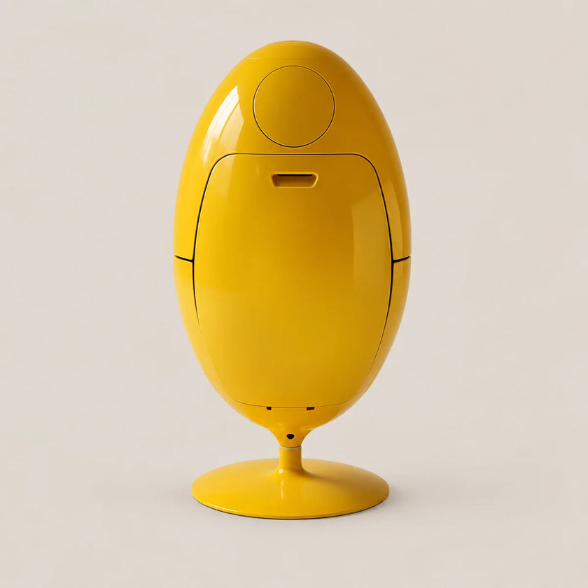 A bright yellow egg-shaped electronic device with a glossy finish, standing on a matching yellow pedestal base against a light beige background.