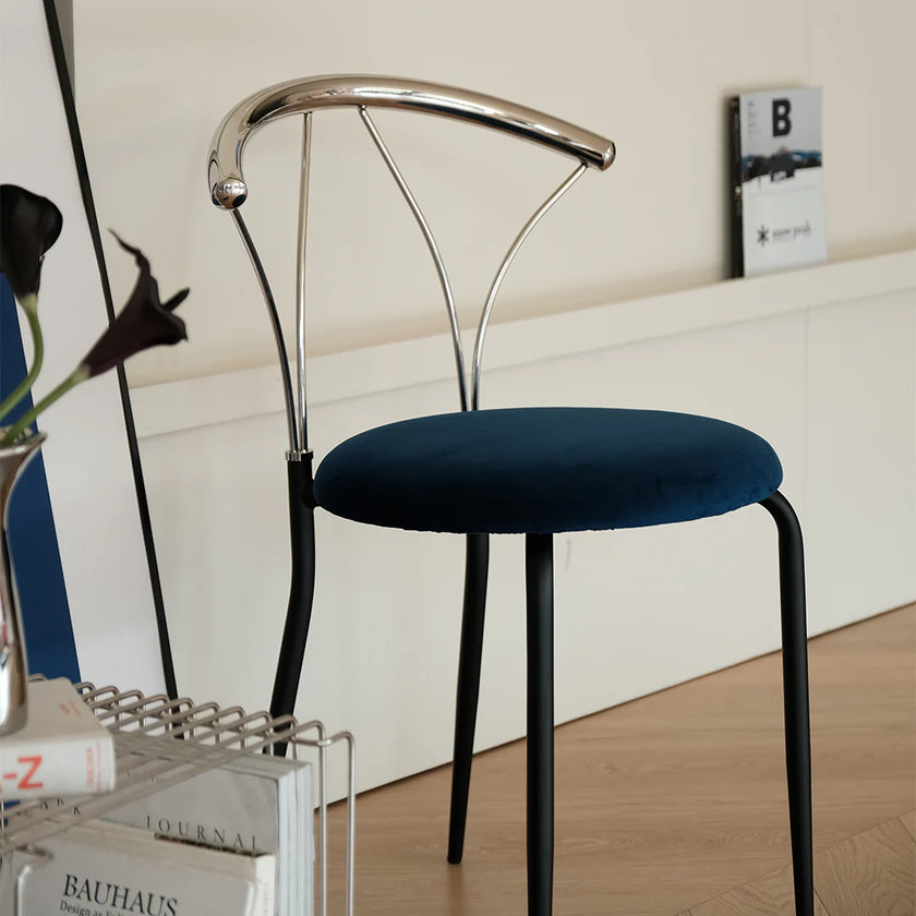 Modern chair with blue seat and metal frame on a wooden floor.