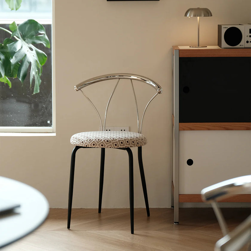 Modern chair with patterned seat in a room with a window and furniture.