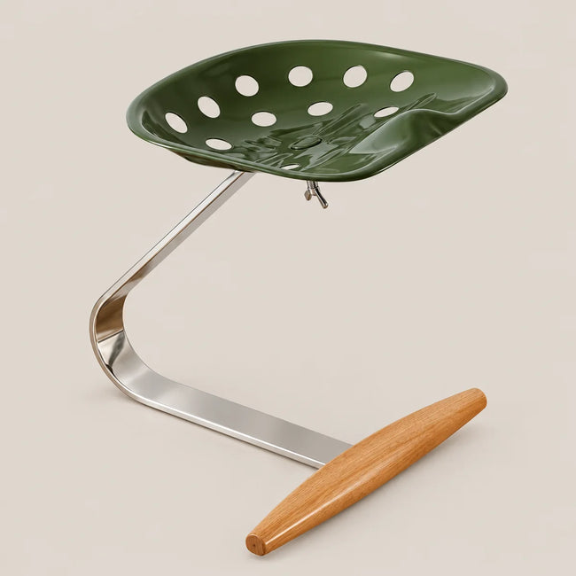 A modern industrial-style stool with a glossy dark green perforated seat, a curved polished steel base, and a light brown wooden footrest, shown on a solid light beige background.