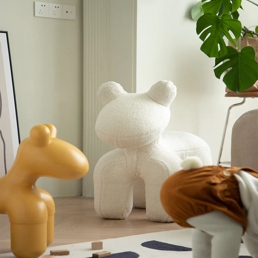 White teddy bear toy in a room with a yellow toy and a brown animal toy.