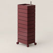 A tall, multi-tier rolling storage cart in a deep burgundy color, featuring a rectangular top tray with a small metal handle and four caster wheels, set against a plain light beige background.