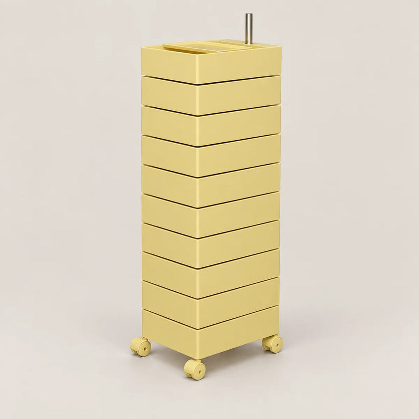 A tall, minimalist rolling storage unit with ten stacked drawers in a pale yellow color, featuring a top tray and four caster wheels, set against a solid light beige background.