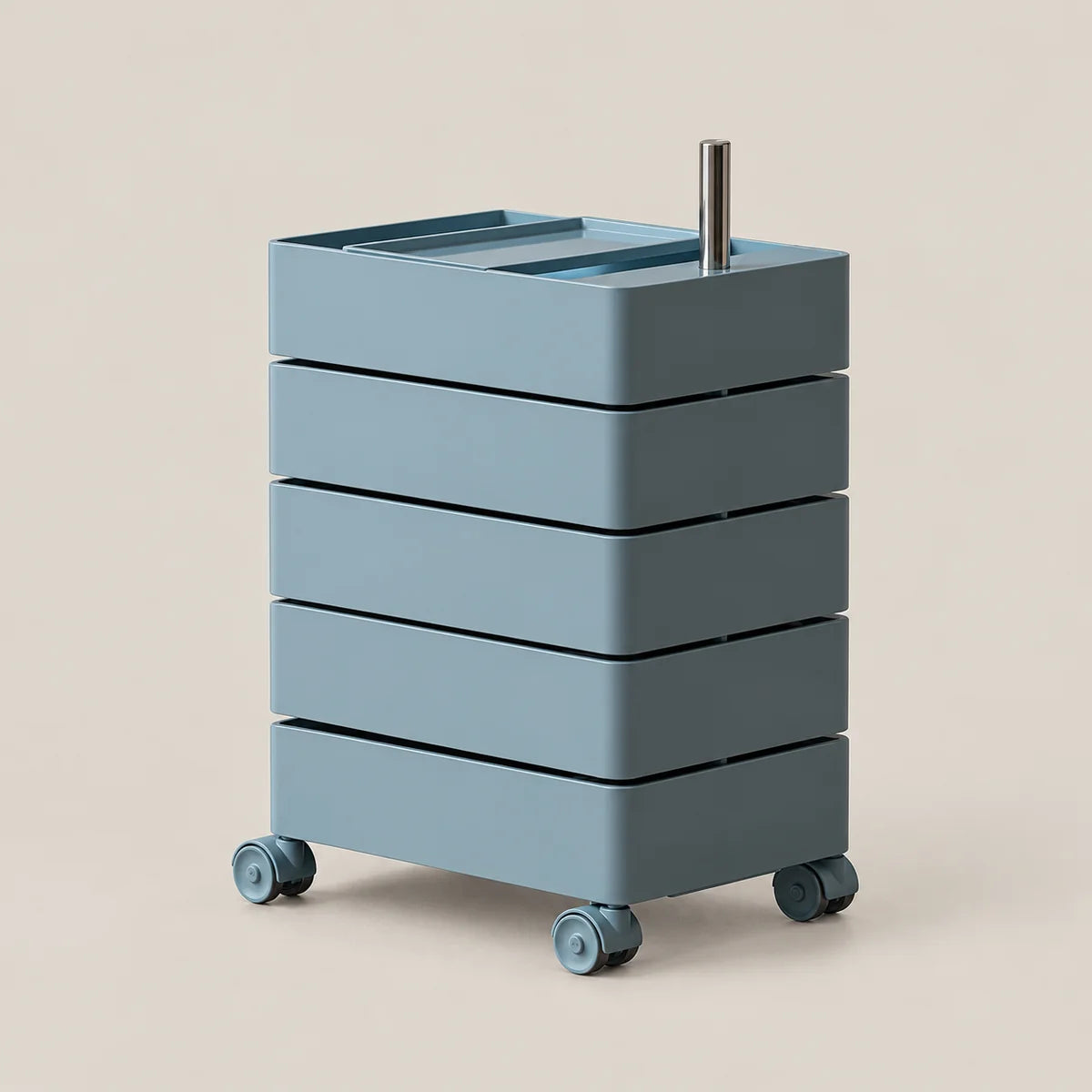 A modern four-drawer rolling storage cart in a muted dusty blue-gray color, featuring a silver metal handle on top and four caster wheels, set against a solid light beige background.