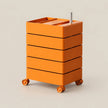 An orange rolling storage cart with five stacked drawers and a top tray, shown on a plain beige studio background.
