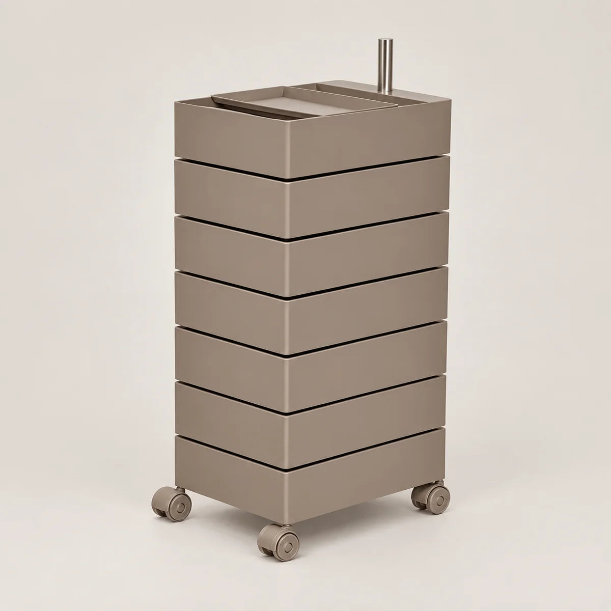 A modern, minimalist rolling storage cart with seven stacked drawers in a warm taupe-brown finish, featuring a matching top tray and dual metal handles, set against a solid light gray background.